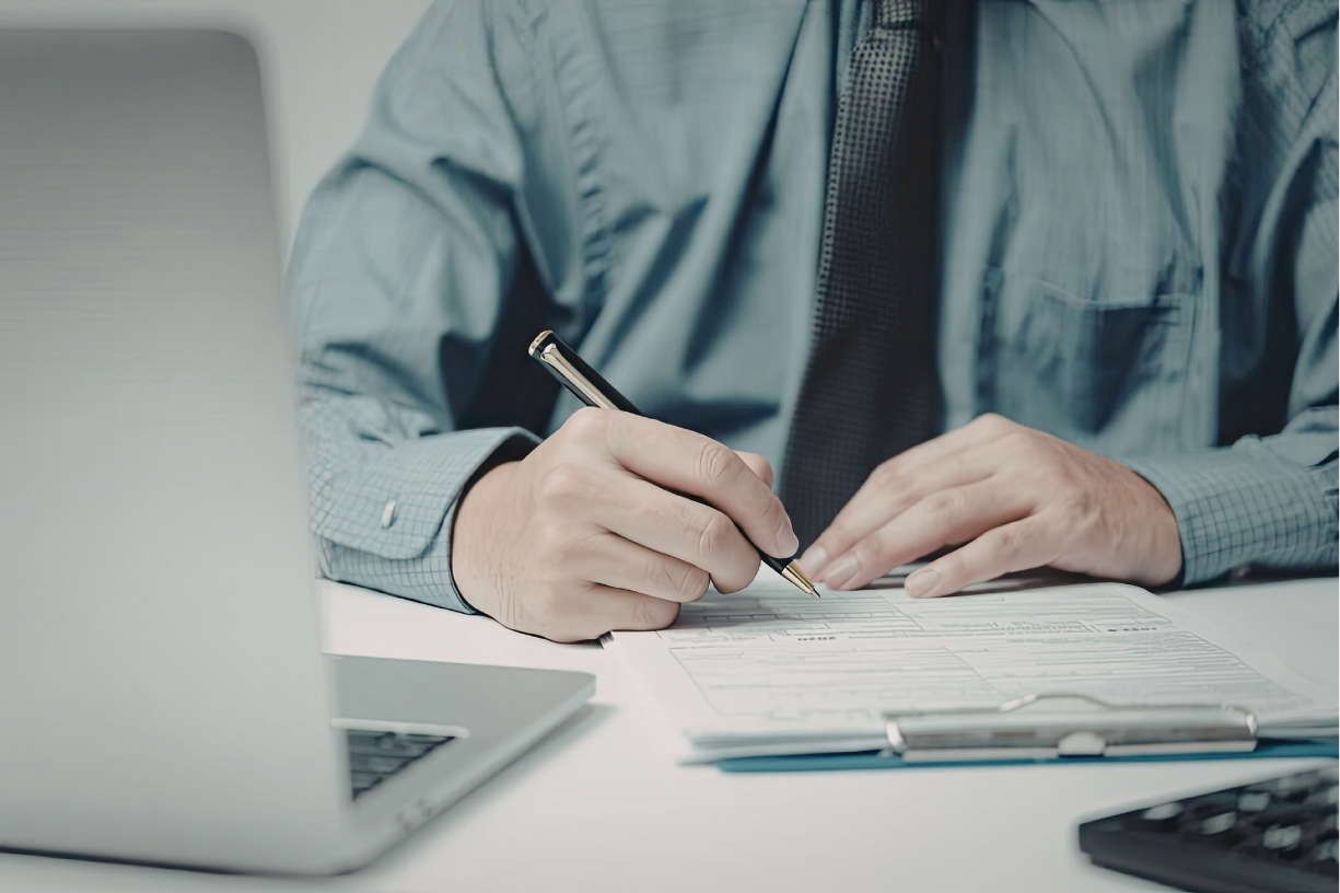 Profissional realizando cálculo de rescisão de contrato com documentos de aviso-prévio e férias